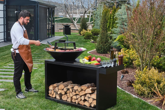 Feuerstelle mit Grillfunktion beim Grillen im Garten